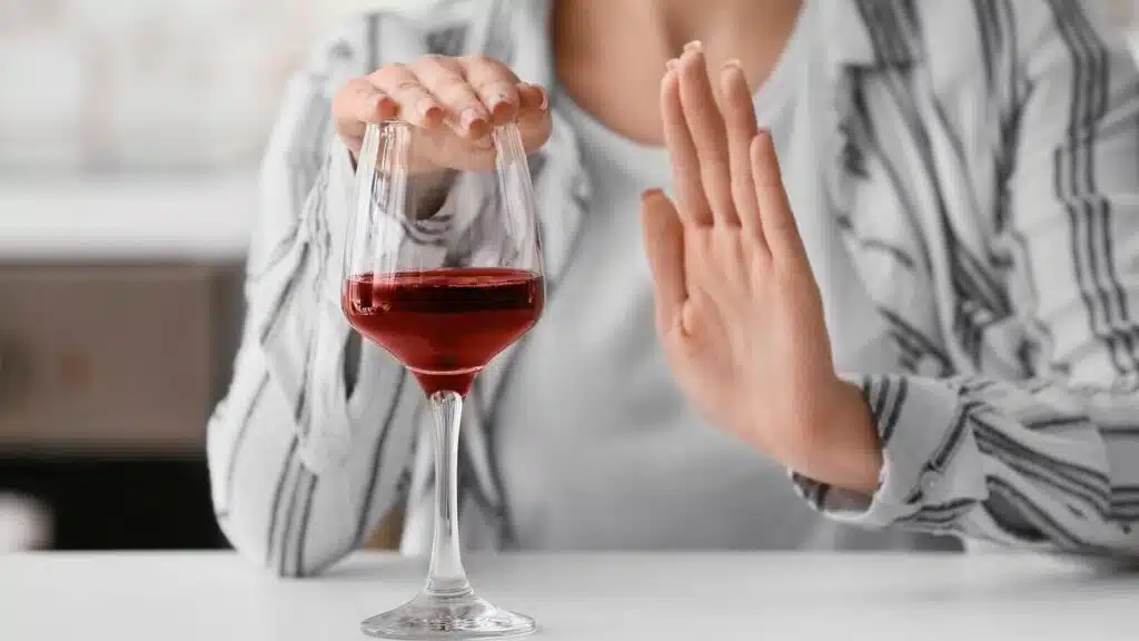 Femme qui refuse de boire un verre de vin